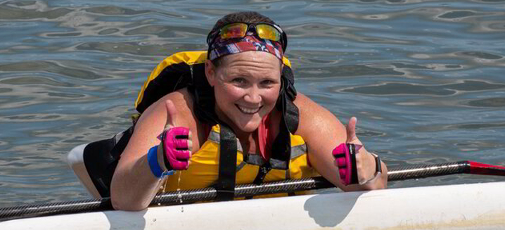 a woman in a life jacket on a boat giving the thumbs up
