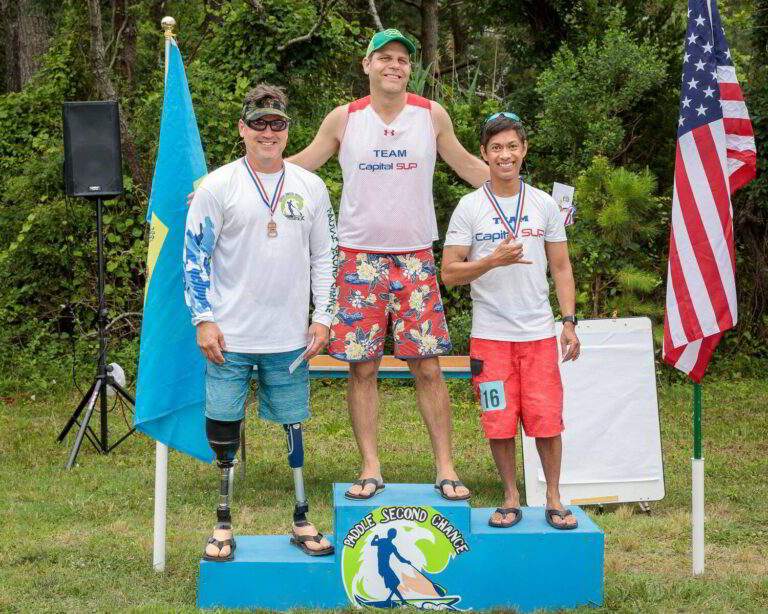 three people standing on a blue podium with two flags