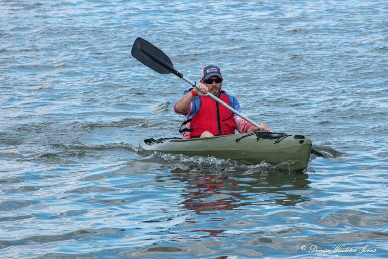 a man in a kayak paddles through the water