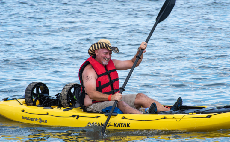 a man in a yellow kayak paddles through the water