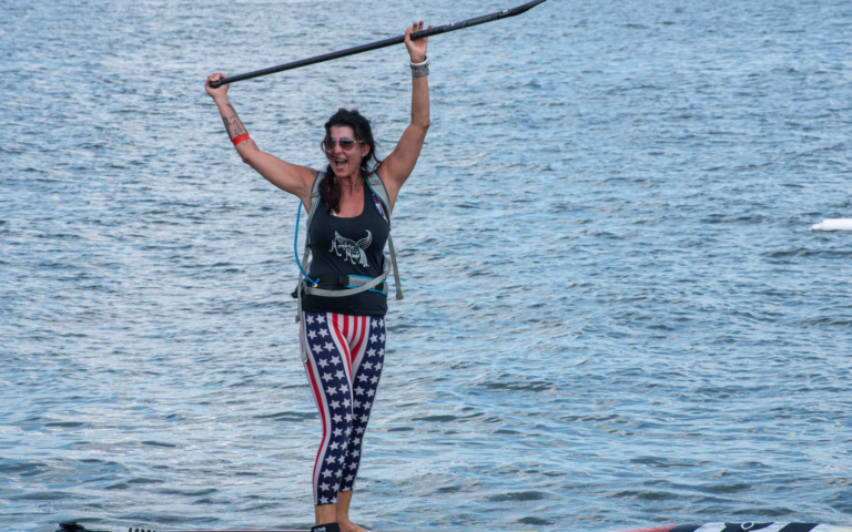 a woman on a surfboard with an american flag leggings