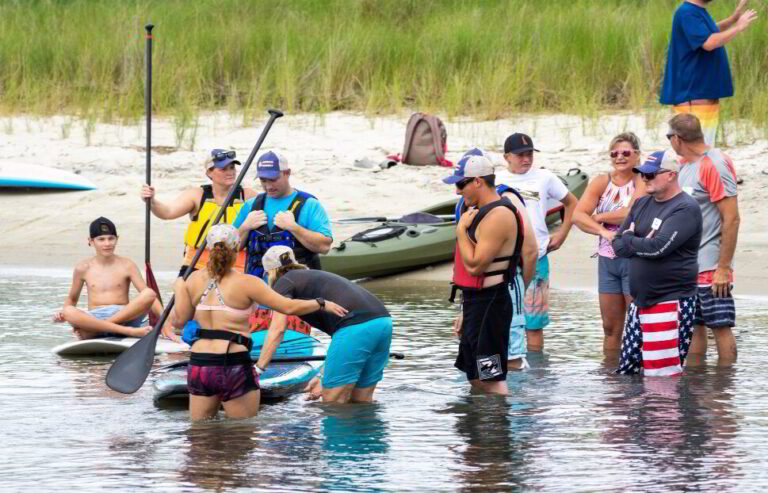 a group of people standing in the water with paddles