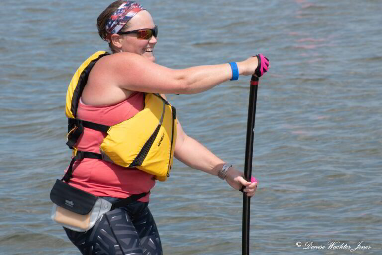 a woman in a life jacket is on a paddle board