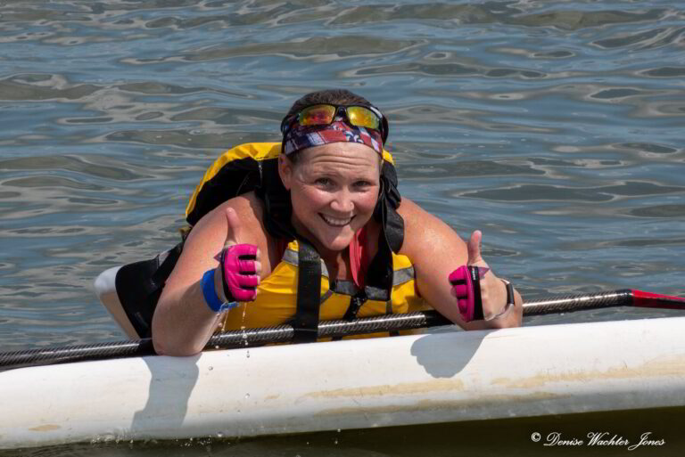 a woman in a life jacket and goggles on a kayak