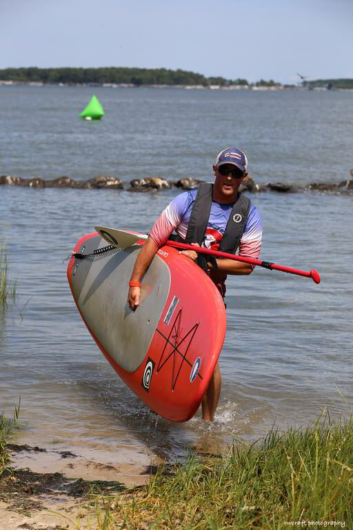 a man carrying a kayak in the water