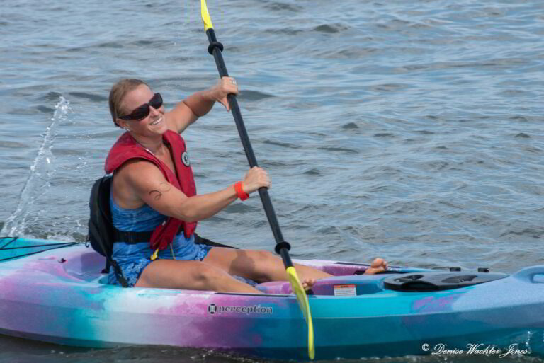 a woman in a kayak paddles through the water