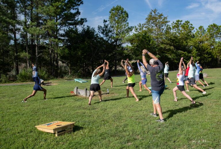 a group of people doing yoga in a field