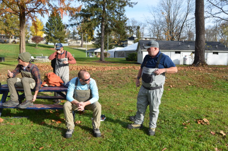 a group of men standing around a park bench