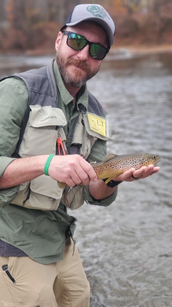 a man holding a brown fish in his hands