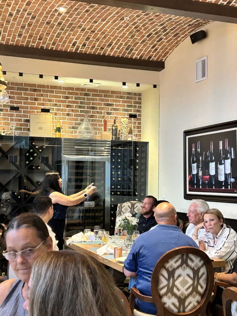 a group of people standing around a wine rack