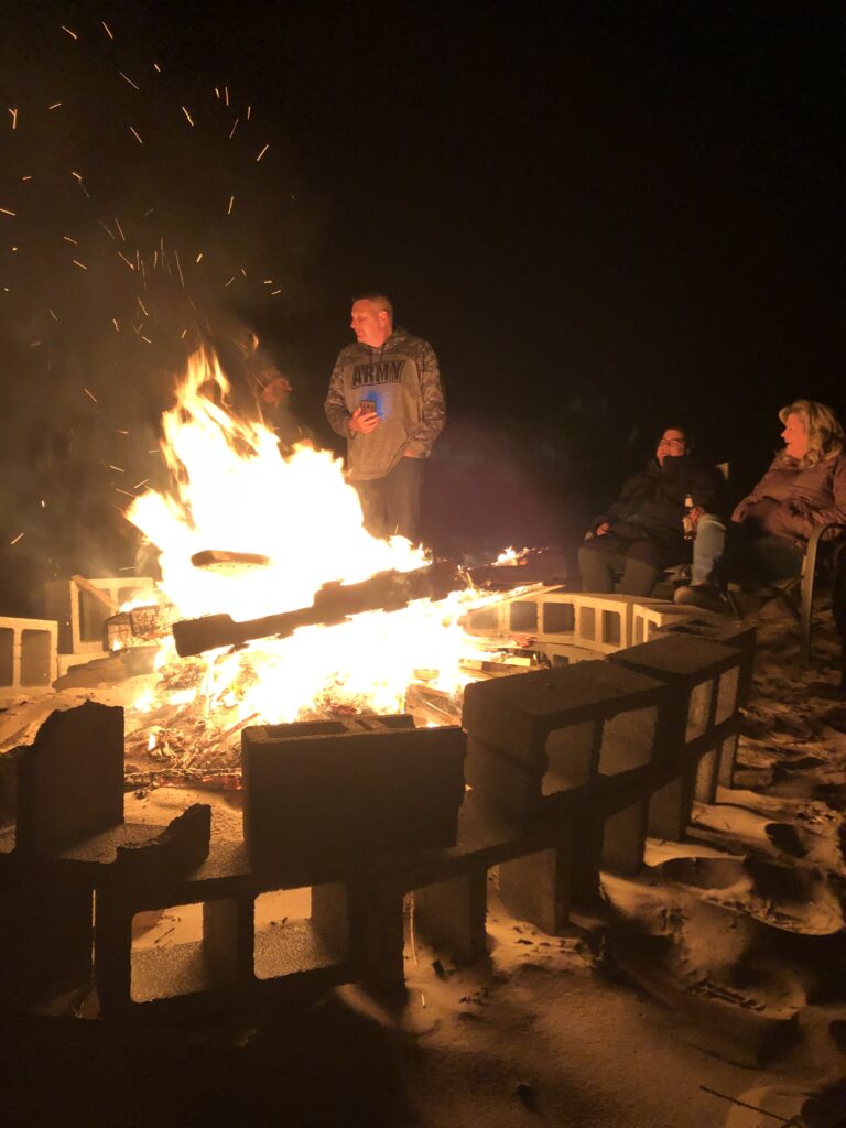a group of people standing around a fire pit