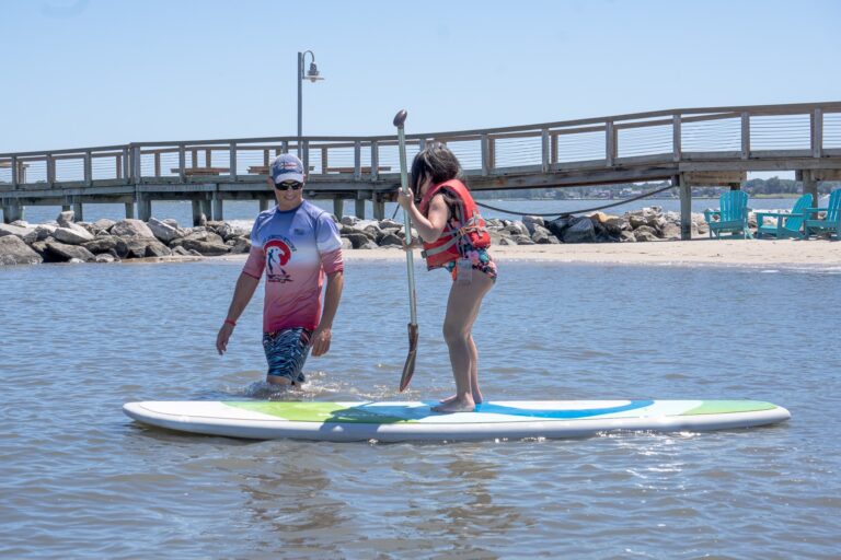 a man and woman standing on surfboards in the water