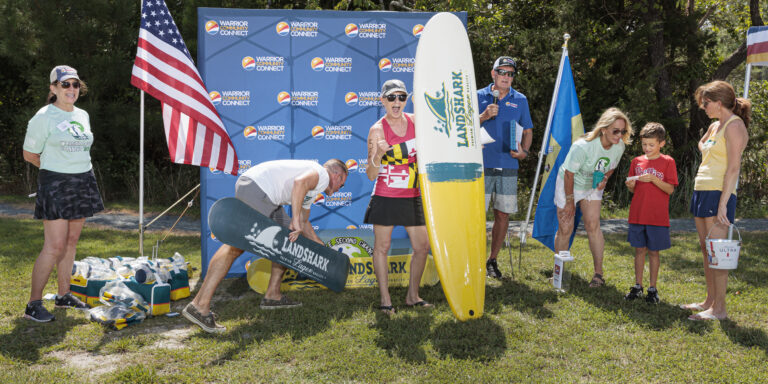 a group of people standing around a surfboard