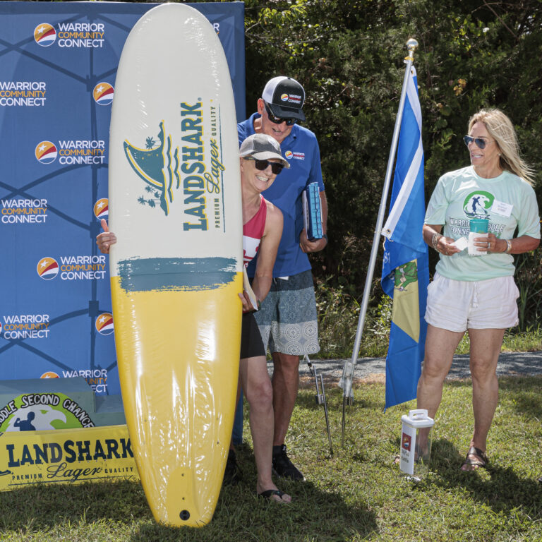 a man and woman standing next to a surfboard