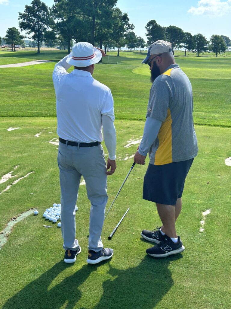 two men standing on a green golf course