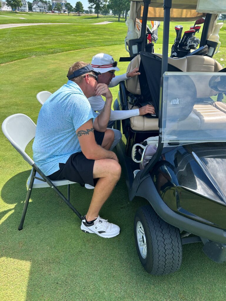 a man sitting in a chair next to a golf cart