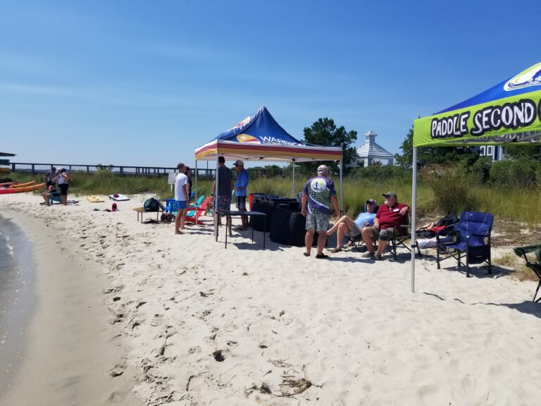 people are sitting under a tent on the beach
