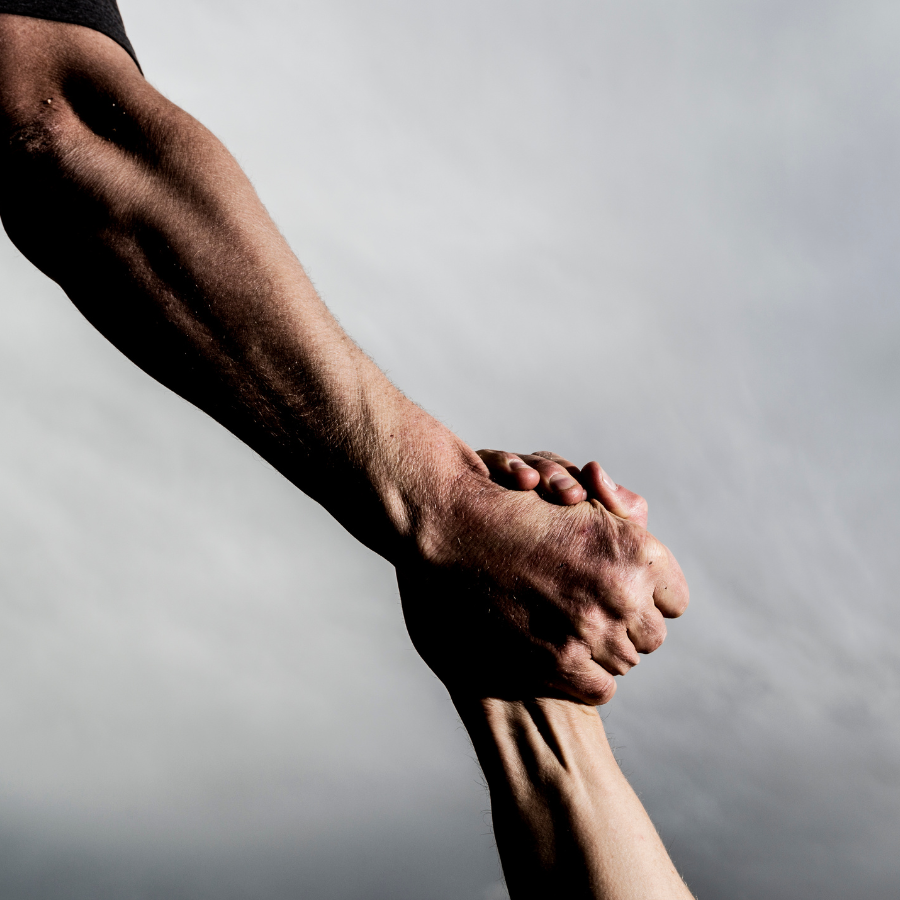 two people holding hands in front of a cloudy sky