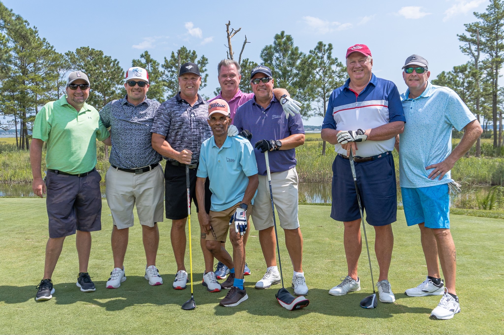 a group of men standing next to each other on a green