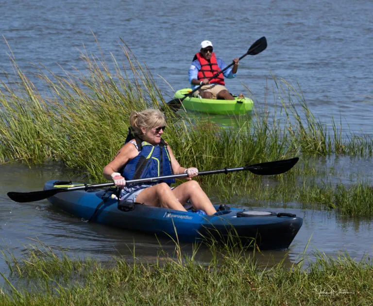 two people in kayaks paddling on the water