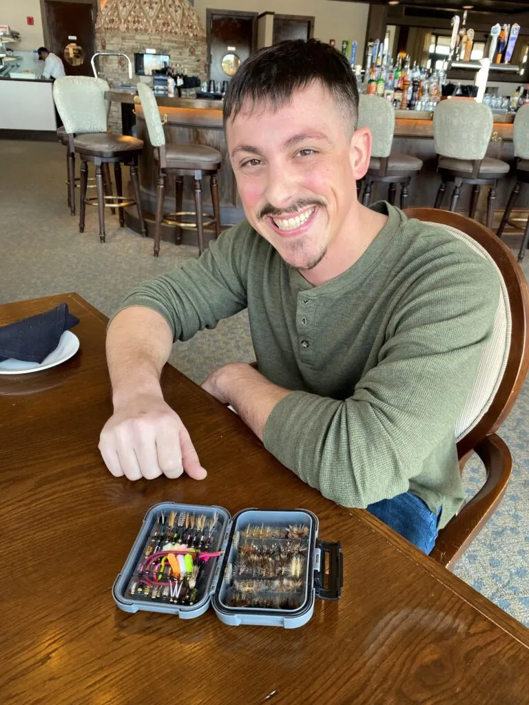 a man sitting at a table with two trays of food