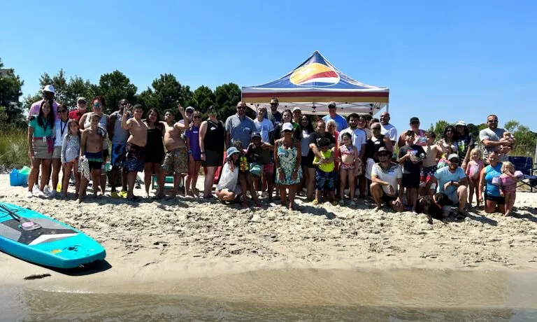 a group of people standing on top of a sandy beach